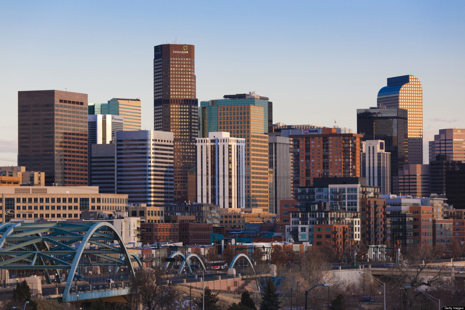 Skyline of a modern city with tall buildings during sunset.