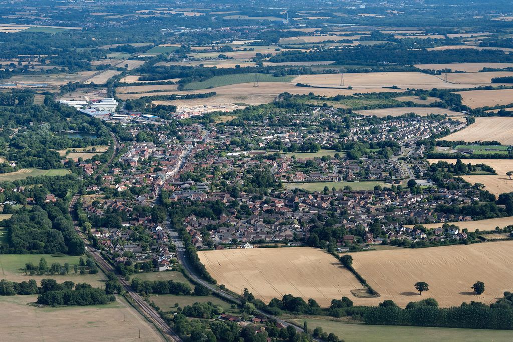 Aerial view of a town surrounded by farmland and greenery.