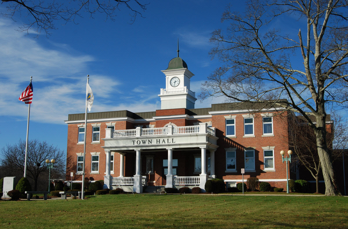Historic red brick courthouse with a clock tower under a clear blue sky.