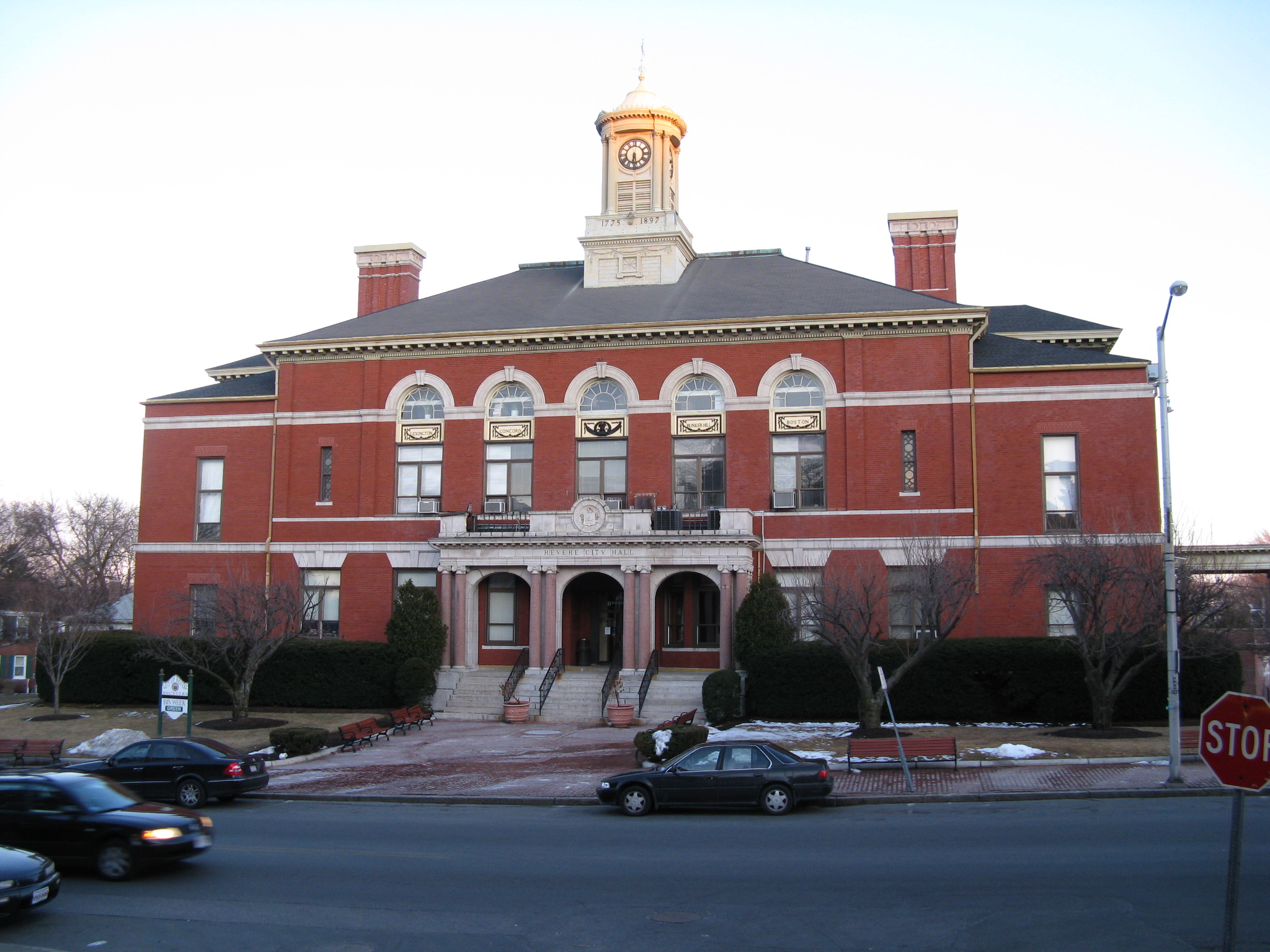 Historic red brick courthouse with clock tower and arched entrances.