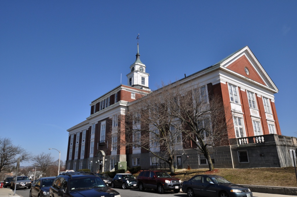 A tall building with a clock tower under a clear blue sky.