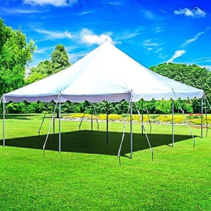 A white party tent set up on green grass under a bright blue sky.
